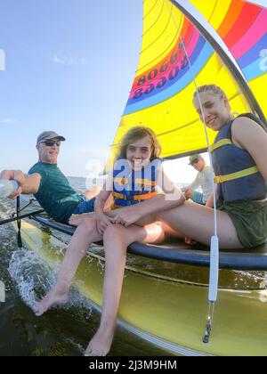 Sailing with friends on a beautiful day. This young girl has Ulrich Congenital Muscular Dystrophy; North Carolina, United States of America Stock Photo