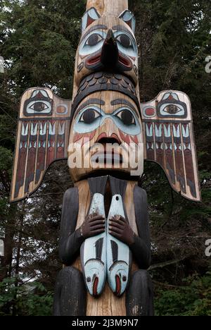 A detail from one of 14  carved and painted poles at Totem Bight State Historical Park in Ketchikan.Midway down the Kadjuk Bird Pole is a Raven is wit Stock Photo