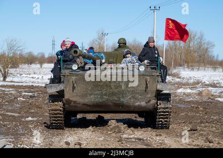 KRASNOE SELO, RUSSIA - MARCH 27, 2022: Visitors to the military-patriotic park 'Steel landing' ride the Soviet amphibious tank PT-76 (Object 740) on a Stock Photo