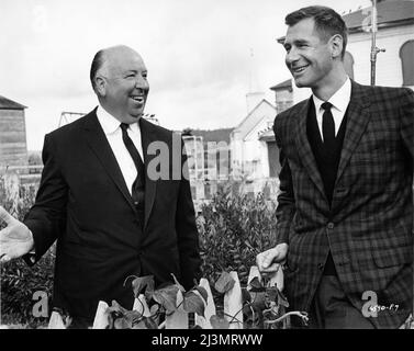 ALFRED HITCHCOCK and screenwriter EVAN HUNTER aka ED McBAIN on set location candid at Bodega Bay California during filming of THE BIRDS 1963 director ALFRED HITCHCOCK from the story by Daphne Du Maurier screenplay Evan Hunter Alfred J. Hitchcock Productions / Universal pictures Stock Photo