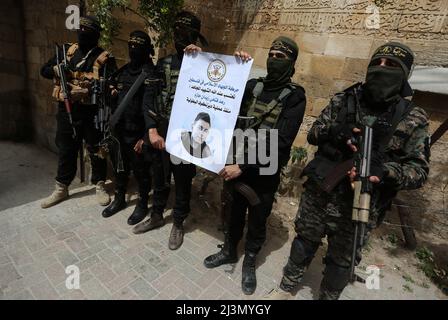 Khan Yunis, Gaza Strip, Palestine. 8th Apr, 2022. Khan Younis, Gaza Strip, Palestine. 08 April 2022. Members of the Al-Quds Brigades, the armed wing of Palestinian Islamic Jihad, attend an event in Khan Younis to pay respect to Raad Hazem, a 28-years-old Palestinian killed by Israeli forces on Friday. Raad Hazem, from the West Bank town of Jenin had allegedly opened fire in a Tel Aviv bar on Thursday night killing two people and injuring several others before being shot-dead on Friday. Thursday's is the latest attack in a recent wave of violence between Palestinians and Israelis. While Israe Stock Photo