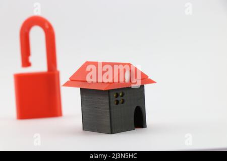 3D printed miniature house with an open padlock on a background showing the concept of a home free from mortgage, Real estate finance concept Stock Photo