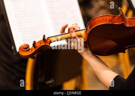 Symphony orchestra on stage, hands playing violin Stock Photo
