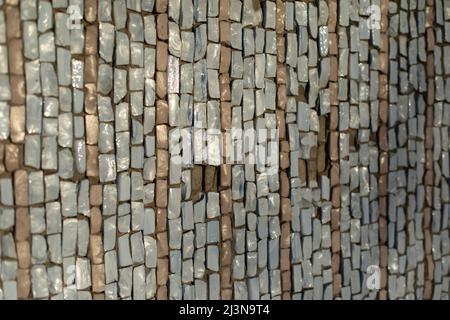 Mosaic texture. Wall is made of pieces of glass. Colored stone. Architecture details. Stock Photo