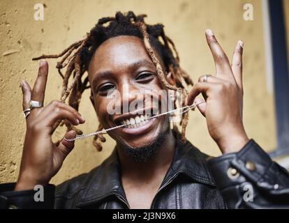 Solid gold. Cropped portrait of a handsome young male gangster showing off his chain while outside on the street. Stock Photo