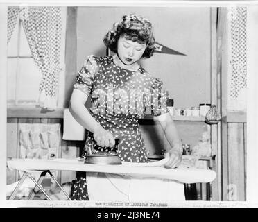 Japanese relocation, California. Ester Naite, an office worker from Los Angeles, is shown operating an electric iron in her quarters at Manzanar, California, a War Relocation Authority center where evacuees of Japanese ancestry will spend the duration. Miss Naito works in an office at the center. Stock Photo