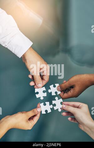 We fit together as a team. Shot of hands putting puzzle pieces together. Stock Photo