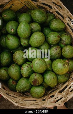 Overhead shot of four green avocados in a rectangular shaped straw fruit  basket Stock Photo - Alamy