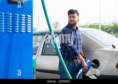 young man fueling car at petrol or gas filling station - concept of transportation, transportation and self-service. Stock Photo