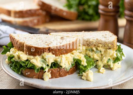 Egg salad and lettuce sandwich on whole grain bread on a plate Stock Photo