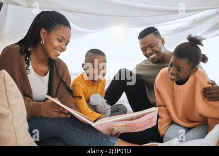 Is this still your favourite story. Shot of a young family reading a story together. Stock Photo