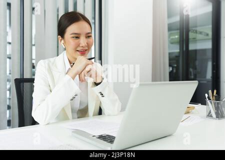 Confidence woman concept, Businesswoman wear bluetooth headphone to meeting on video conference. Stock Photo