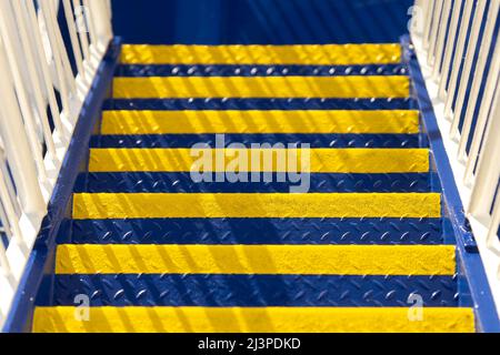 Industrial stairway newly painted in bright yellow and rich blue Ukrainian flag colours on sunny day. Colours of Ukraine. Stock Photo