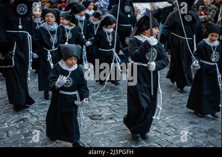 A little child is seen holding a drum. In Spain, Holy Week is called 'Semana  Santa' and it's celebrated with unrivaled pageantry and emotion. It comes  with religious processions around the country