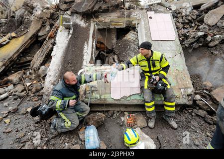 April 9, 2022, Borodyanka of Bucha Raion, Kyiv Oblast, Ukraine: Search and rescue workers rest on the wreckage of a damaged residential building by the Russian airstrike, in Borodyanka of Bucha Raion, Kyiv Oblast, as they continue to search for bodies buried underneath the wreckage, amid the Russian invasion. (Credit Image: © Daniel Ceng Shou-Yi/ZUMA Press Wire) Stock Photo