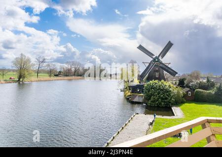 Weesp, Netherlands. 09 apr 2022.  View on windmill 'de Eendragt' and river Vecht from the stage of windmill 'de Vriendschap' during a record attempt of the Voluntary Millers Guild to have all Dutch rotating wind and water turbines in the Netherlands run simultaneously between 11:00 and 12:00. More than 800 mills  participated, including 29 mills abroad. Credit: Steppeland/Alamy Live News Stock Photo