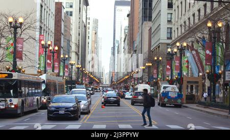 CHICAGO, ILLINOIS, UNITED STATES - DEC 11, 2015: Urban canyons between downtown skyscrapers, with cars in the foreground