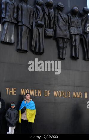 A Mother and her child stand in front of 'The Women of World War II' Memorial on Whitehall during a protest against the Russian invasion of Ukraine. W Stock Photo