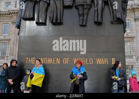 Protestors standing in front of 'The Women of World War II Memorial on Whitehall, London. UK. Stock Photo