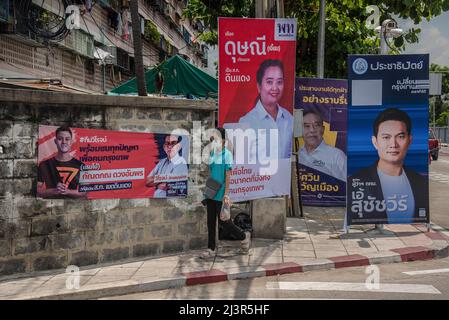 March 30, 2022, Bangkok, Thailand: A pedestrian walks past Bangkok governor election campaign posters showing candidates Guntapon Duangamporn, Viroj Lakkana-adisorn, Dutsanee Tiandech, Aswin Kwanmuang and Suchatvee Suwansawat during the preparations for the forthcoming Bangkok gubernatorial and city councilor elections in Bangkok. The eleventh election for the governorship of Bangkok will be held on May 22, 2022 that is the first Bangkok governorship elections in nine years since 2013 after the military seized power in a 2014 coup. (Credit Image: © Peerapon Boonyakiat/SOPA Images via ZUMA Pres Stock Photo