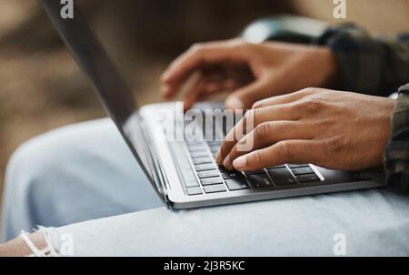 Living and learning. Cropped shot of a man using a laptop on campus. Stock Photo