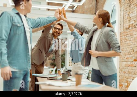 Smiling colleagues showing team work in office Stock Photo