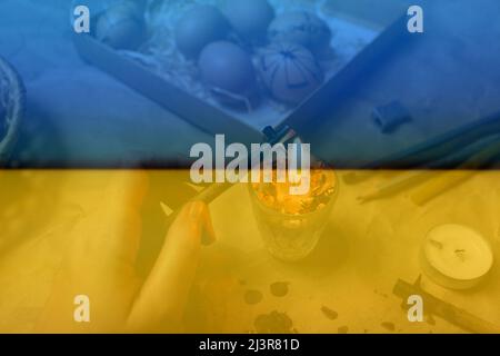 Female hand holding pen, pysachok, near flame and heating it. Preparing for painting Ukrainian Easter eggs decorated with folk designs using a wax res Stock Photo