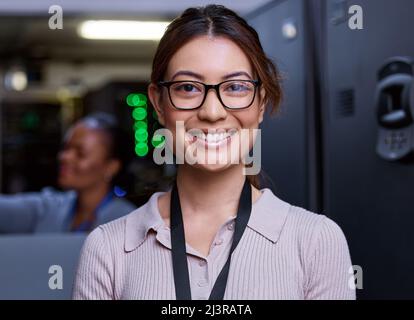 Trust me, your severs are in good hands. Cropped portrait of an attractive young female programmer working in a server room with her colleague in the Stock Photo
