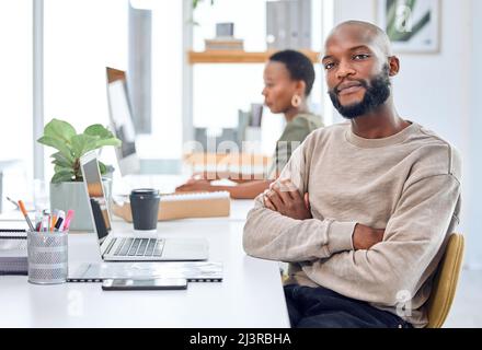 Find what youre passionate about then go after it. Portrait of a confident businessman sitting at his desk. Stock Photo