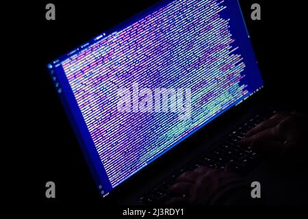 Freelance web developer working at night, programming the web with javascript like a hacker. Close-up hand and computer Stock Photo