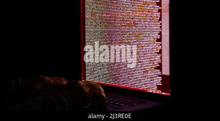 Freelance web developer working at night, programming the web with javascript like a hacker. Close-up hand and computer Stock Photo