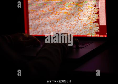 Freelance web developer working at night, programming the web with javascript like a hacker. Close-up hand and computer Stock Photo