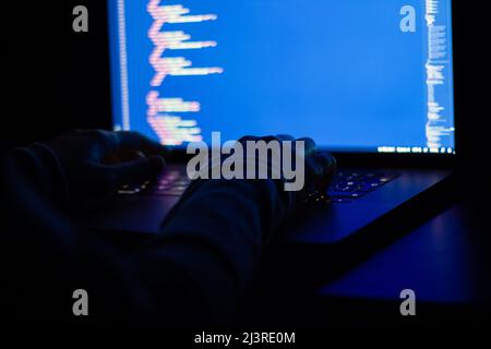 Freelance web developer working at night, programming the web with javascript like a hacker. Close-up hand and computer Stock Photo