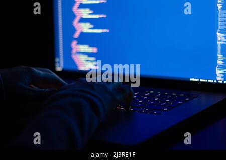 Freelance web developer working at night, programming the web with javascript like a hacker. Close-up hand and computer Stock Photo