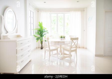 Home interior. Dining room design. Table and chairs in white sunny house. Kitchen breakfast area in family apartment. Stock Photo