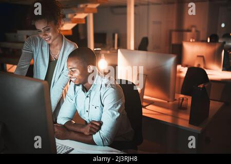 Getting some help. High angle shot of two young designers working together on a computer in their office. Stock Photo