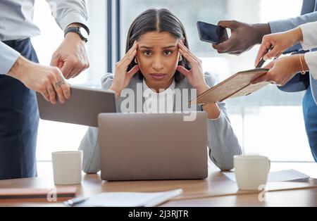 This is too much for me. Shot of a young businesswoman feeling stressed out in a demanding office environment at work. Stock Photo