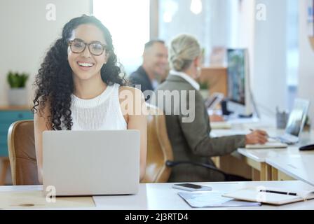 Ive got everything I need right here. Shot of a young businesswoman using a laptop in an office at work. Stock Photo