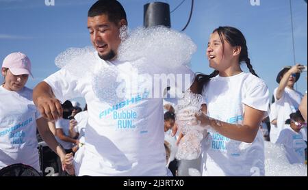 Pomona, USA. 9th Apr, 2022. People participate in the Bubble Run in Pomona, Los Angeles County, California, the United States, April 9, 2022. Thousands of people joined an annual five-kilometer Bubble Run in Pomona in Southern California on Saturday. Credit: Zeng Hui/Xinhua/Alamy Live News Stock Photo