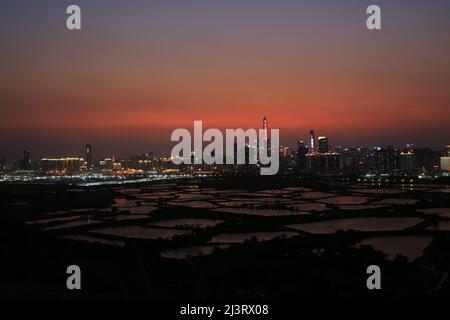 Shenzhen skyline , with skyscrapers and office against fish farm or fish ponds, during dramatic moment in evening, from the view of boundary of Hong K Stock Photo