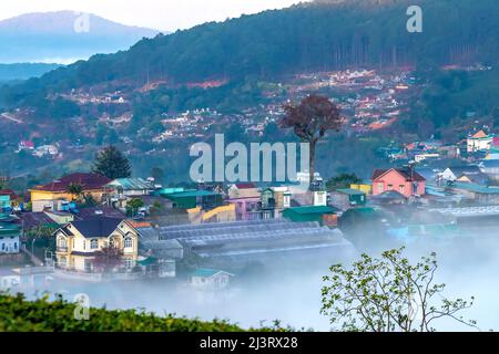 Morning landscape in a small town blurred in the morning mist with dawn sky background is peaceful in highlands Da Lat, Vietnam Stock Photo