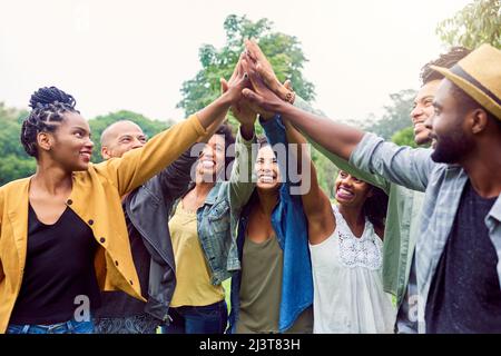 Were each others motivation. Shot of a group of friends reaching for a high five. Stock Photo