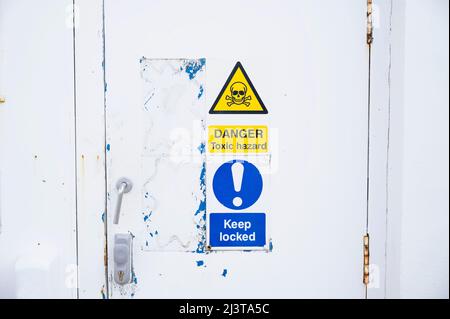 Toxic hazard danger sign on industrial factory door Stock Photo