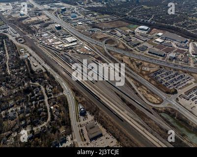 A high aerial view above a train yard located in a busy urban area during the day.