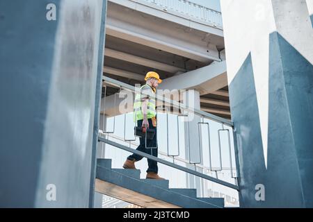 Wide angle view at builder standing in unfinished apartment building on construction site, copy space Stock Photo