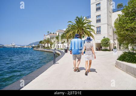 TIVAT, MONTENEGRO - JULY 15, 2021: Man and woman tourists walking along the promenade of Porto Montenegro Stock Photo