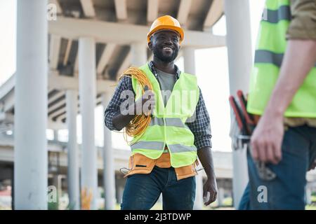 Two workers standing on concrete floor of construction site and discussing project Stock Photo