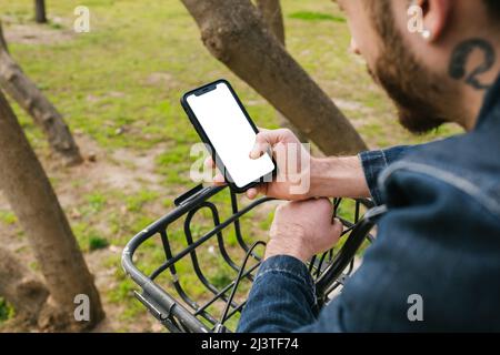 White screen, young man holding phone and leaning on handlebar of bicycle, background copy space for advertise, contact, marketing, business, technolo Stock Photo