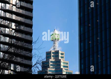 The TD (Toronto-Dominion Bank) logo is seen atop the TD Canada Trust Tower, through buildings in downtown Toronto. Stock Photo