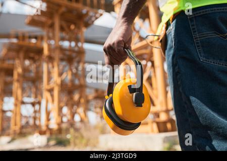 Professional engineers in workwear standing at construction site and discussing building process Stock Photo